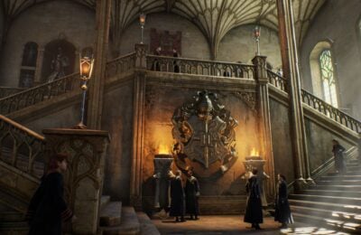 Feature image for our Hogwarts Legacy friendships guide. It shows a staircase in Hogwarts with a number of students stood around talking.